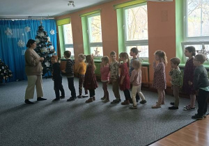 Dzieci ustawiają się w kolejce przed prowadzącą zajęcia