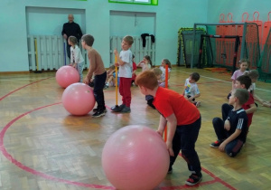 dzieci podczas ćwiczenia w toczeniu piłki