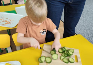 Chłopiec kroi ogórka