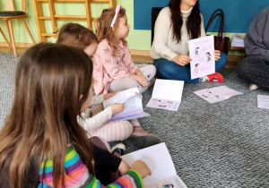Dzieci słuchają opowiadania czytanego przez prowadzącą zajęcia