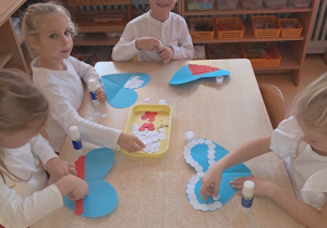 Dzieci ozdabiają serce biało - czerwonymi barwami