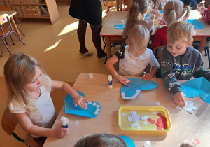 Dzieci ozdabiają serce biało - czerwonymi barwami