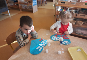 Dzieci ozdabiają serce biało - czerwonymi barwami