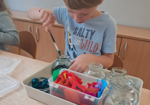 Chłopiec podczas barwienia i przelewania wody