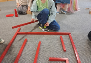 Chłopiec podczas działań z czerwonymi sztangami