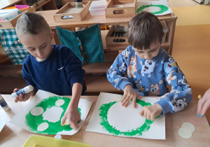 Dzieci wyklejają elementy wieńca adwentowego