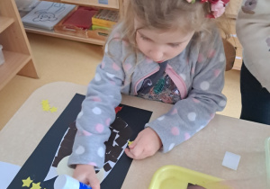 Dziewczynka wykonuje pracę plastyczną