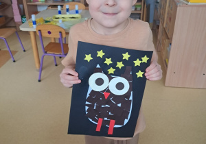 Chłopiec prezentuje pracę pt. "Sowa"