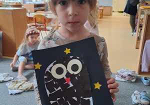 Dziewczynka prezentuje pracę pt. "Sowa"