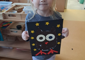 Dziewczynka prezentuje pracę pt. "Sowa"