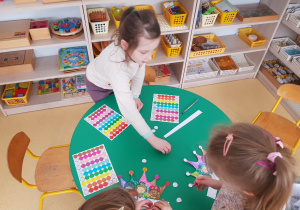 Dzieci ozdabiają korony kolorowymi kołami