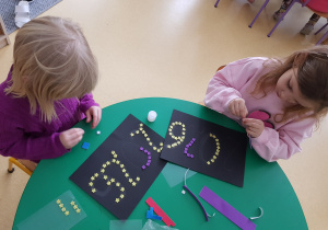 Dzieci starsze wyklejają rok 2026 z kolorowych elementów