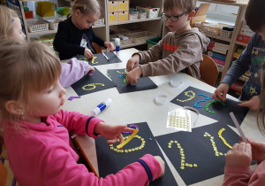 Dzieci starsze wyklejają rok 2026 z kolorowych elementów