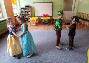 Dzieci w przebraniach karnawałowych tańczą parami