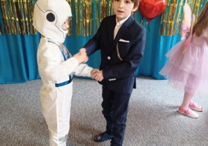 Chłopcy w przebraniach karnawałowych tańczą parami