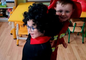 Chłopcy w przebraniach tańczą w rytm muzyki