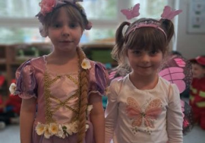 Dziewczynki w przebraniu Roszpunki i Motylka pozują do zdjęcia