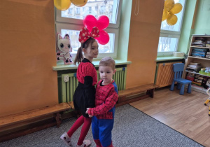 Dziewczynka w stroju myszki tańczy z chłopcem w stroju Spidermana