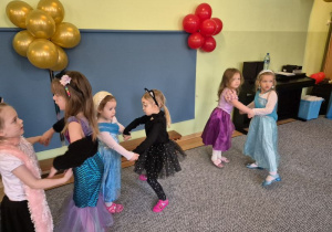 Dziewczynki w przebraniach karnawałowych tańczą parami