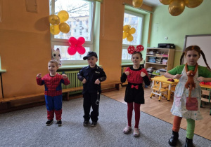 Dzieci w strojach: Spidermana, policjanta, myszki i Pipi stoją obok siebie podczas tańca