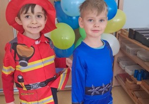 Chłopcy prezentują strój strażaka i wojownika