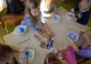 Dzieci kolorują śnieg akwarelami