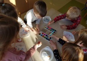 Dzieci kolorują śnieg akwarelami