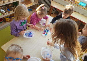 Dzieci kolorują śnieg akwarelami