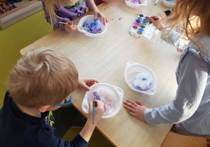 Dzieci kolorują śnieg akwarelami