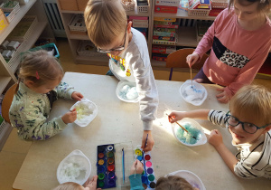 Dzieci kolorują śnieg akwarelami