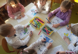 Dzieci kolorują obrazek z pingwinem