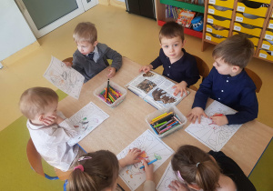 Dzieci kolorują obrazek z pingwinem