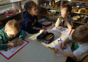 Dzieci kolorują obrazek z pingwinem