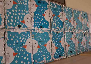 Wystawa prac dzieci na tablicy przed salą o tematyce zimowej