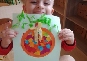 Antoś prezentuje wykonaną przez siebie pracę plastyczną przedstawiającą bombkę