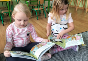 dzieci oglądające książeczki o tematycze finansów