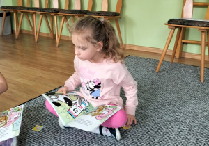 Michasia ogląda książeczkę o tematyce finansów