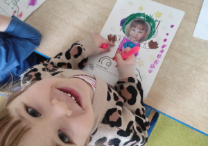 Dziewczynka koloruje pracę plastyczną: ,,Ja w kosmosie".