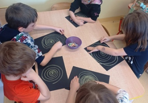 Dzieci w trakcie kreślenia spiralnej galaktyki