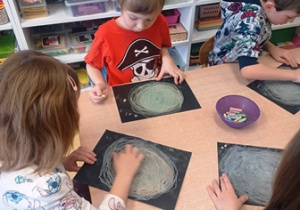 Dzieci wykonują pracę plastyczną "Galaktyka"