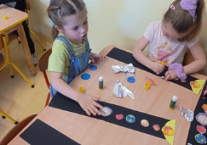 Dziewczynki w czasie działania przy stolikach