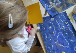 Dziewczynka wycina księżyc.