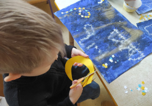 Chłopiec wycina księżyc.