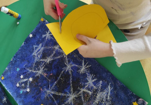 Dziewczynka wycina księżyc.