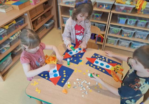 Dzieci przy stoliku w czasie wykonywania pracy plastycznej pracy pt. "Podróż w kosmos"