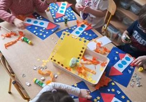 Dzieci przy stoliku w czasie wykonywania pracy plastycznej pracy pt. "Podróż w kosmos"