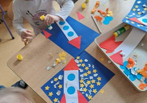 Dzieci przy stoliku w czasie wykonywania pracy plastycznej pt. "Podróż w kosmos"
