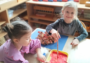 Zosia z Julą malują farbami słońce ze zgniecionego papieru