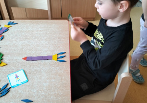 Filip układa z klocków rakietę