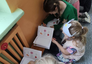 Dzieci wykonują rysunki w książeczkach